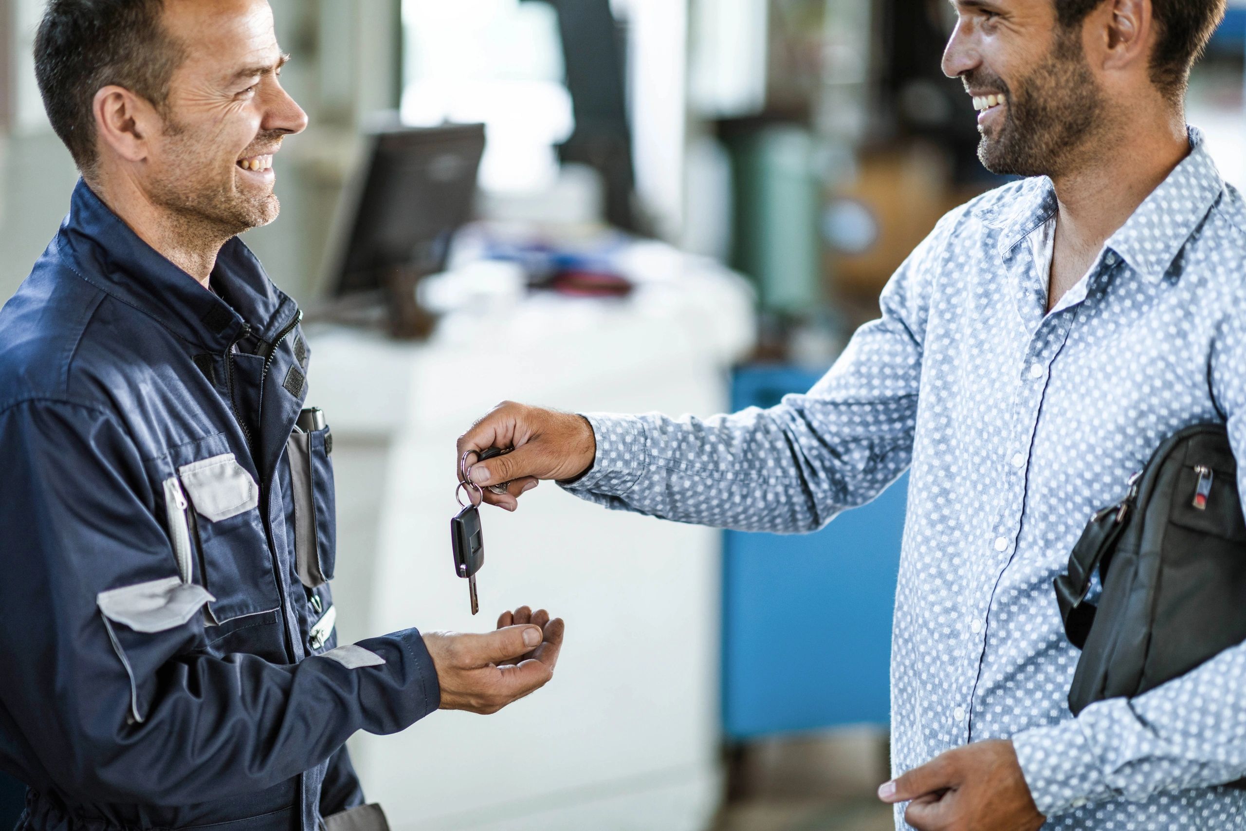 Customer handing car keys to an auto mechanic