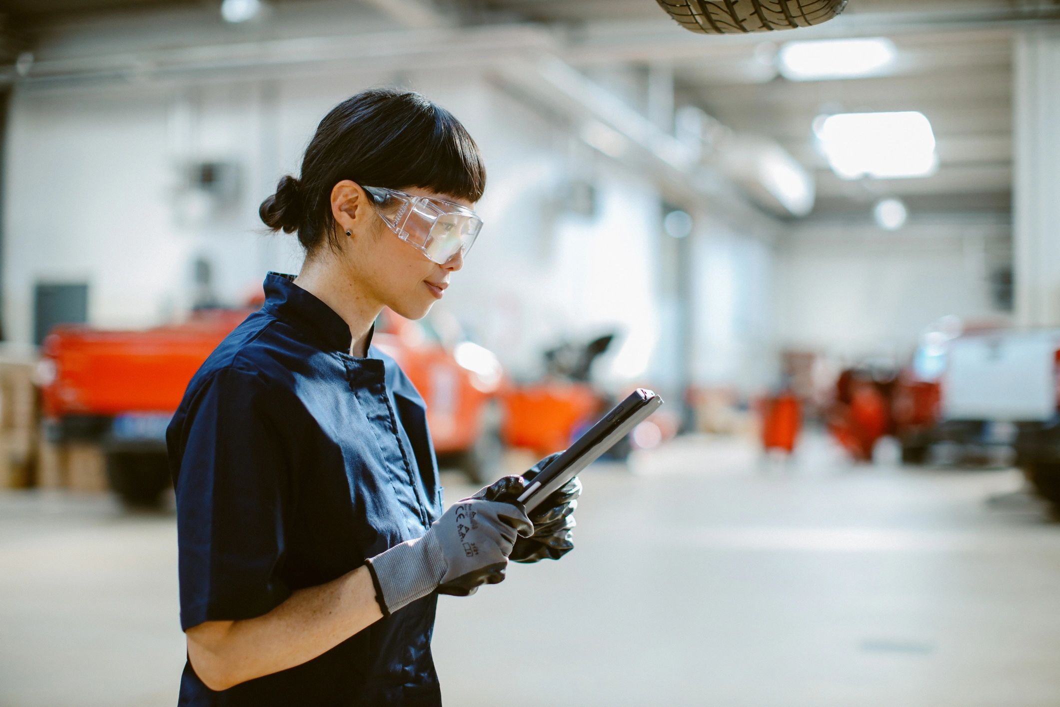 Mechanic in a car repair shop using a tablet